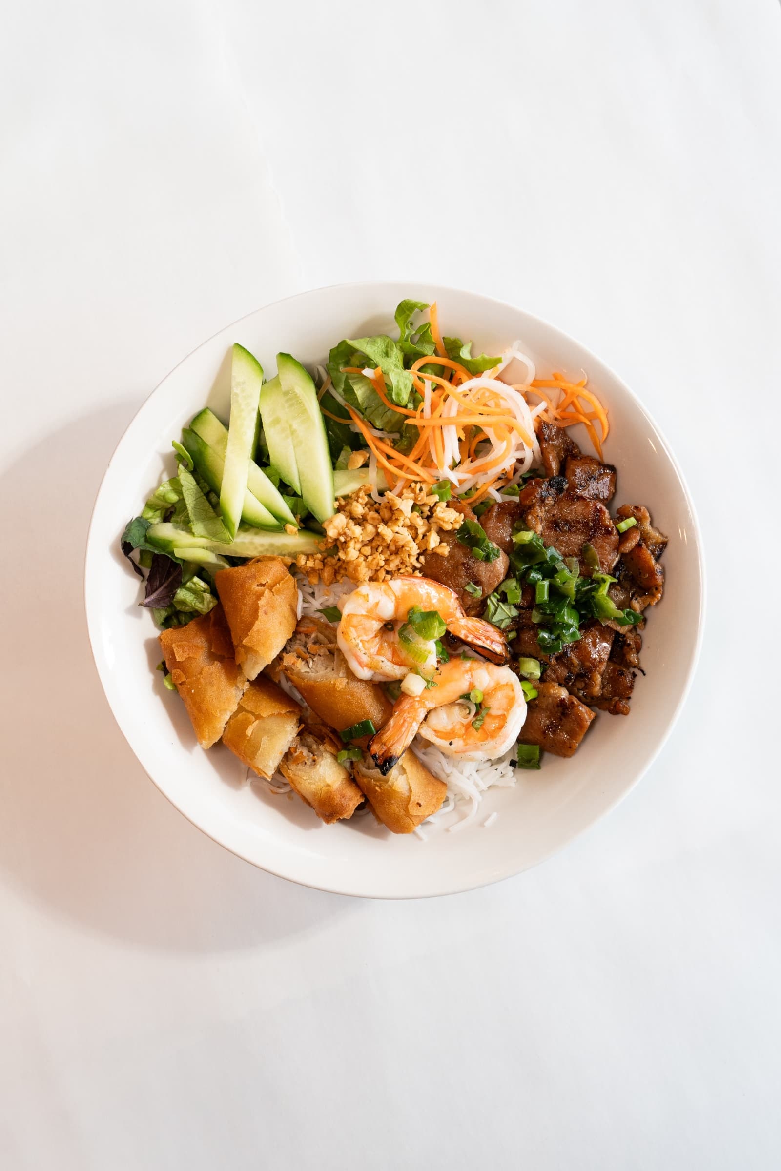 A bún bowl with grilled meat, vermicelli, herbs and pickled vegetables at Khoi Hung Restaurant