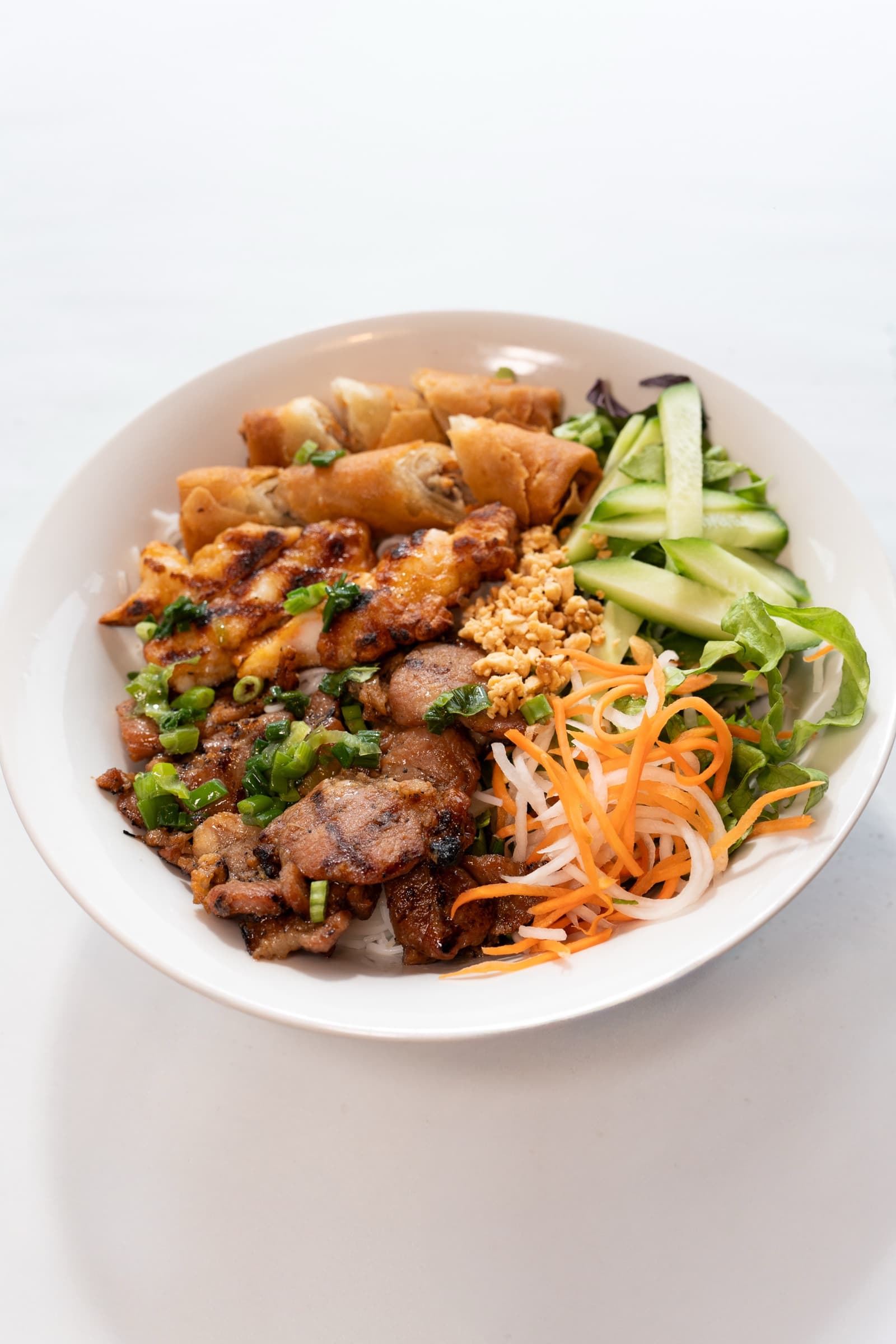 A bún bowl with grilled pork, vermicelli, herbs and pickled vegetables at Khoi Hung Restaurant