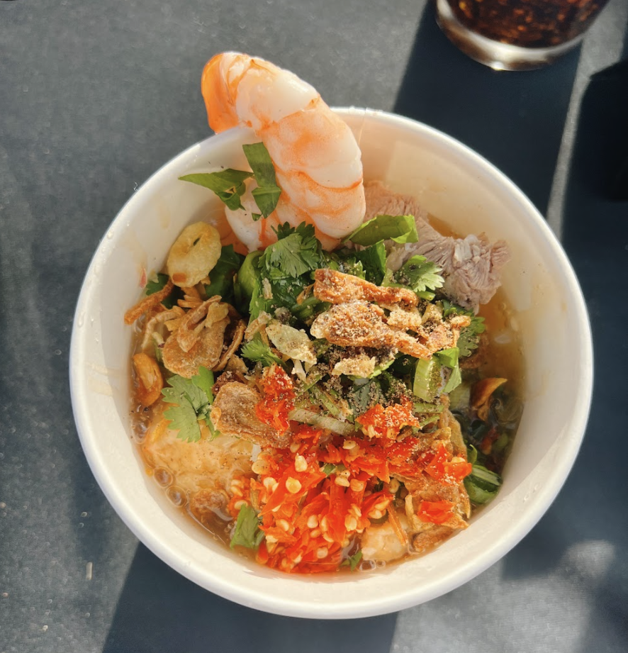Steaming bowl of Banh Canh noodle soup viewed from above showing thick noodles and garnishes